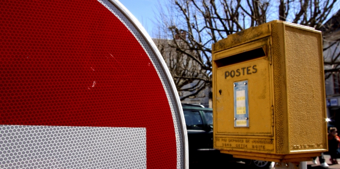 boîte aux lettres à côté d'un panneau de sens interdit