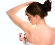 une femme s'applique un spray déodorant