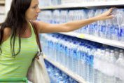 jeune femme achetant de l'eau en bouteille dans un supermarché