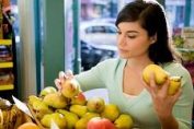 une cliente choisit des fruits dans une boutique