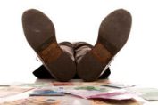 homme allongé sur un tas de billets de banque