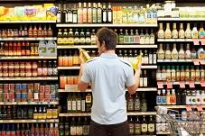 client hésitant dans le rayon d'un supermarché
