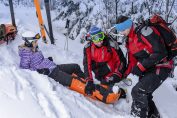 skieuse soignée par deux sauveteurs