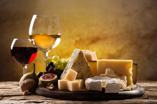 Un plateau de fromages avec deux verres de vin