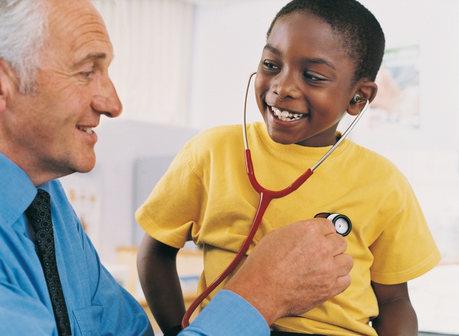 Un médecin fait écouter son coeur avec un stétoscope à un petit garçon