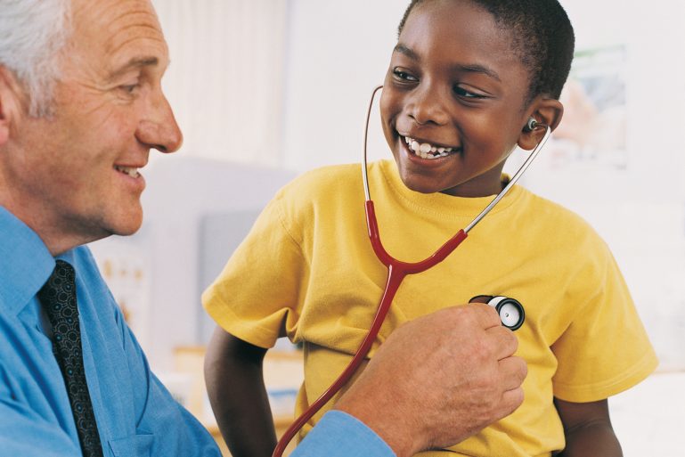 Un médecin fait écouter son coeur avec un stétoscope à un petit garçon
