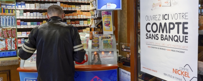 client d'un buraliste à côté d'une affichette “Ouvrez ici votre compte sans banque”