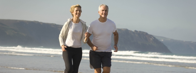 couple âgé courant sur la plage