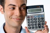 homme souriant tenant une calculatrice