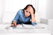 jeune femme inquiète, calculette à la main
