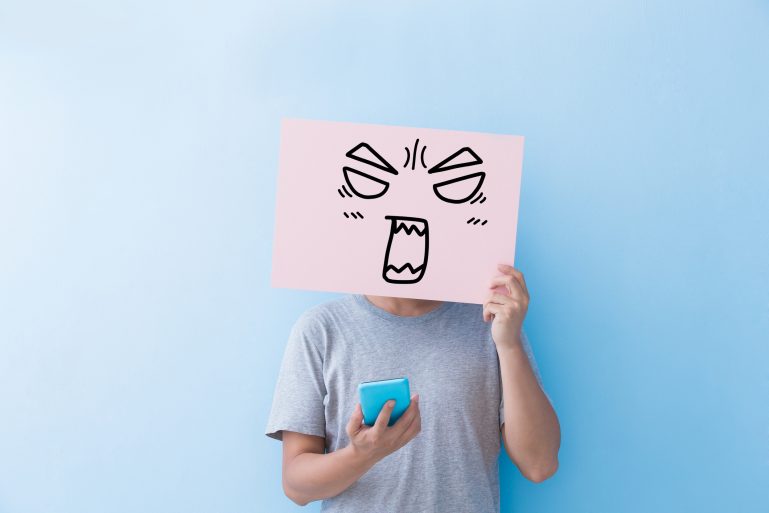 utilisateur de smartphone avec un dessin de visage énervé