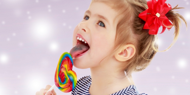 Une petite fille suce une sucette