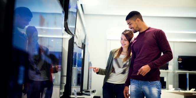 Un couple regarde des téléviseurs dans un grand magasin