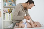Un père s'amuse avec son bébé au moment du change