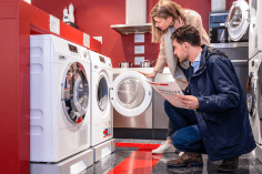 Un couple regarde les lave-linge dans un magasin