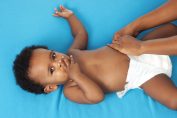 mains attachant la couche d'un bébé