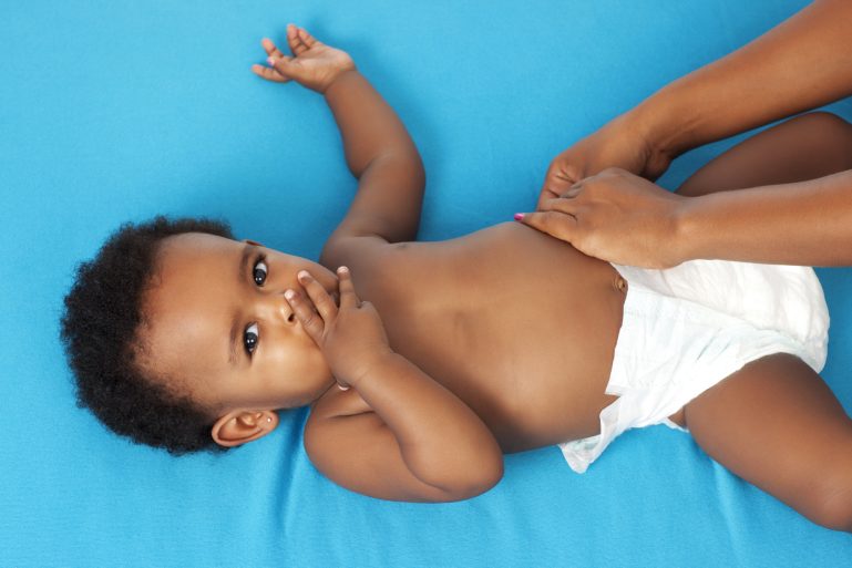 mains attachant la couche d'un bébé