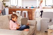 jeune garçon avec ordinateur portable sur un canapé