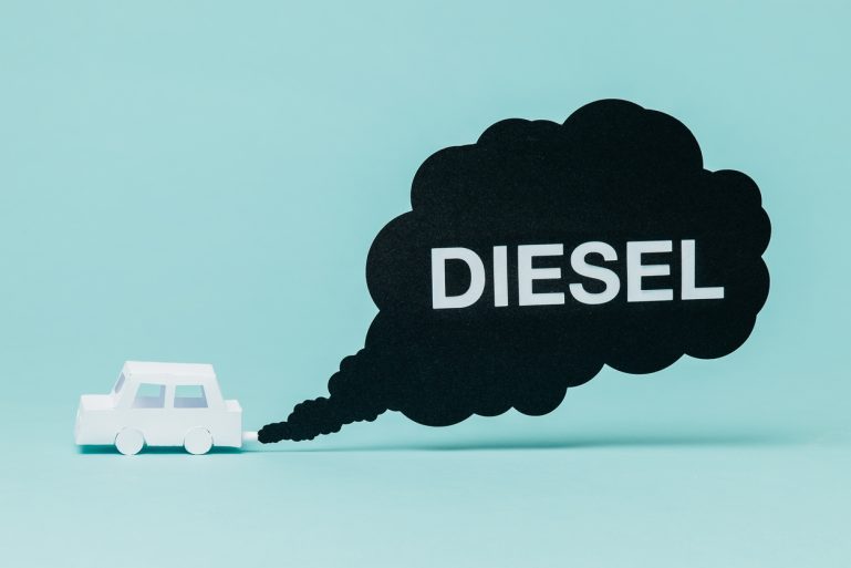 Un dessin d'une voiture en carton qui émet un gros nuage noir avec le mot Diesel