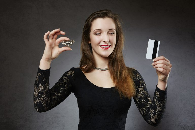 une femme avec un diamant dans une main et une carte bancaire dans l'autre