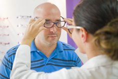 Une opticienne teste des lunettes sur un client