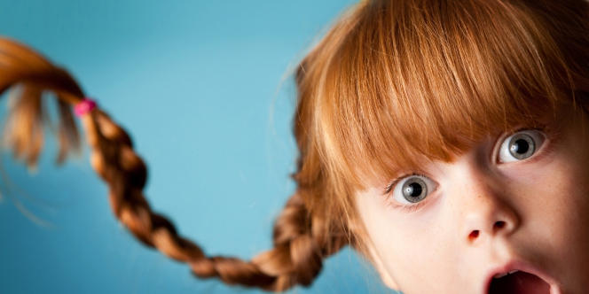 Une petite fille rousse à la couette virevoltante