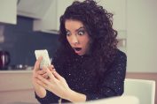 Une femme ébahie devant son smartphone