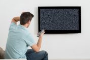 Un téléspectateur devant un écran de télé en panne