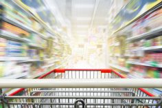 Un caddy file dans les rayons d'un supermarché
