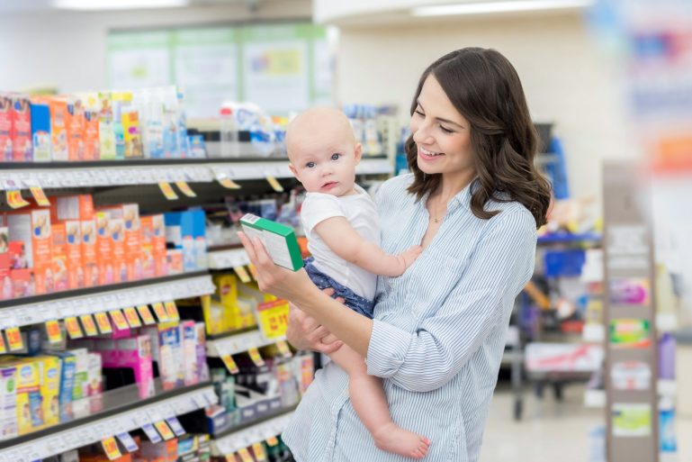 bébé et femme regardant les médicaments dans une pharmacie