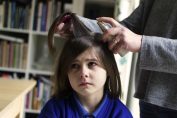 Une petite fille se fait traiter contre les poux