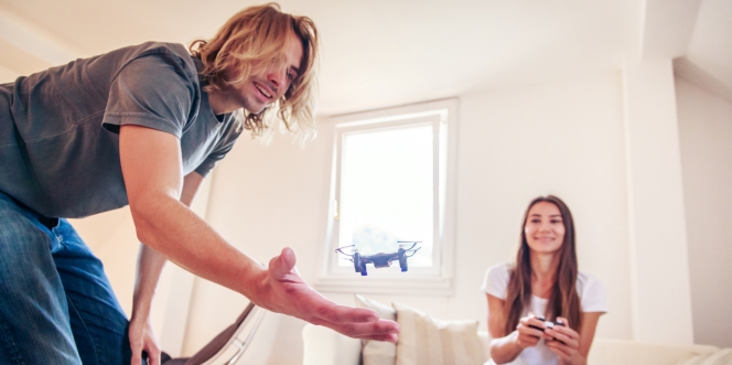 couple jouant avec un drone dans son salon