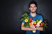 Un homme tient dans ses bras des légumes