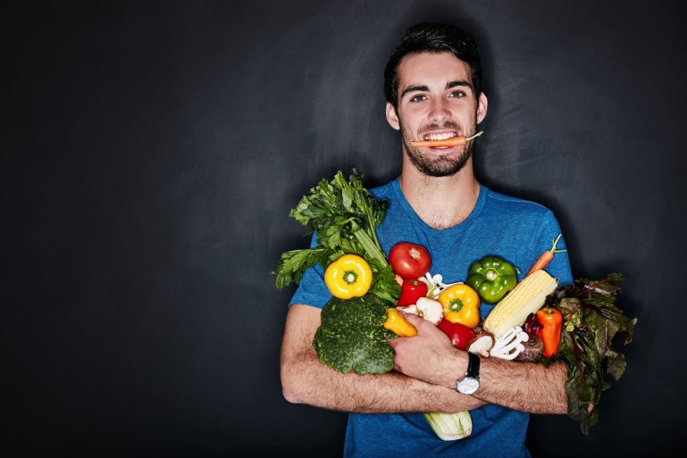 Un homme tient dans ses bras des légumes
