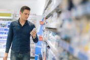 Un homme dans un supermarché regarde son smartphone