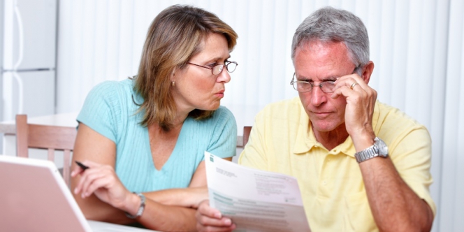 Un couple discute avec un relevé de comptes à la main