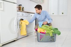 Un homme sort du linge de son lave-linge