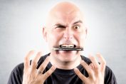 Homme en colère avec un téléphone dans la bouche