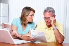 Un couple discute avec un relevé de comptes à la main