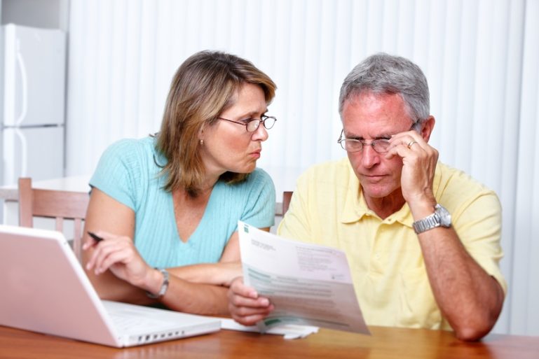 Un couple discute avec un relevé de comptes à la main