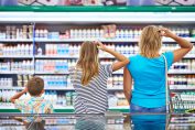Une famille face à un rayon de supermarché en train de se gratter la tête