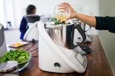Quelqu'un place des ingrédients dans le bol d'un thermomix