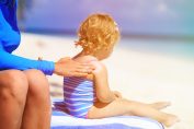 sur la plage, enfant et crème solaire