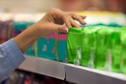 Une femme choisit un paquet de serviettes hygiéniques dans un magasin