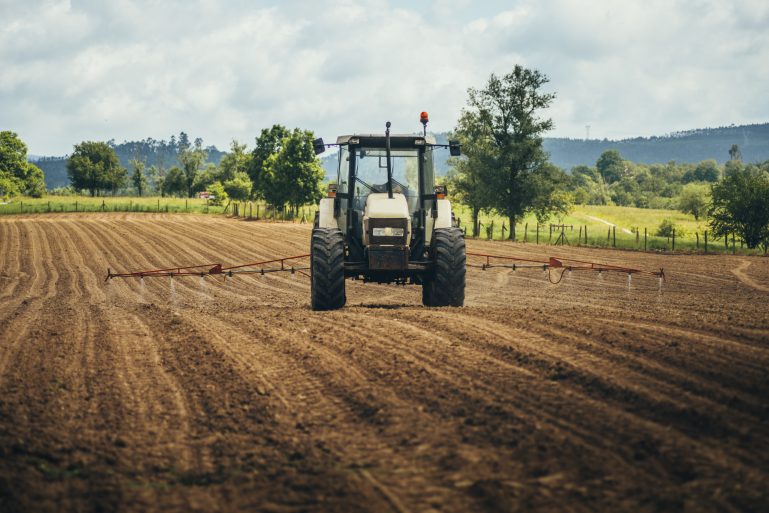 Un tracteur traite un champ avant semis