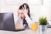 femme effarée qui se tient la tête devant un écran d'ordinateur