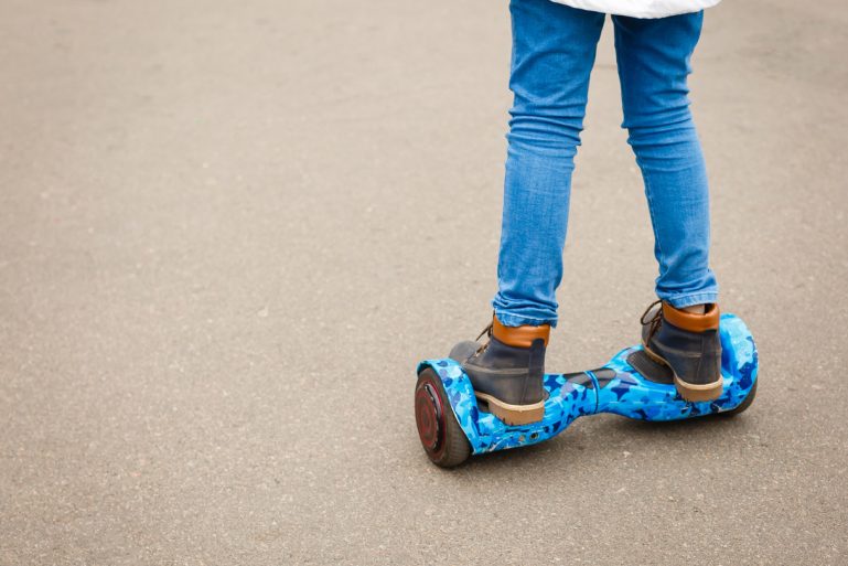 Les jambes d'un enfant en équilibre sur un hoverboard