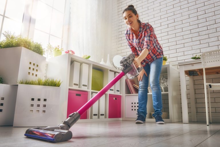 Femme passant l'aspirateur balai