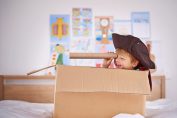 un enfant joue au pirate dans un carton