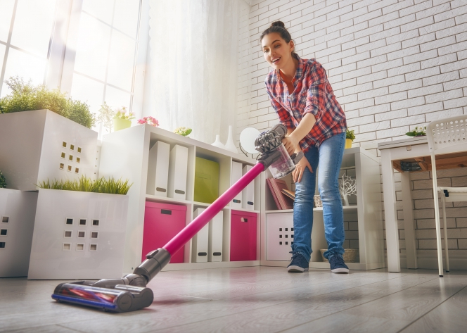 Femme passant l’aspirateur balai